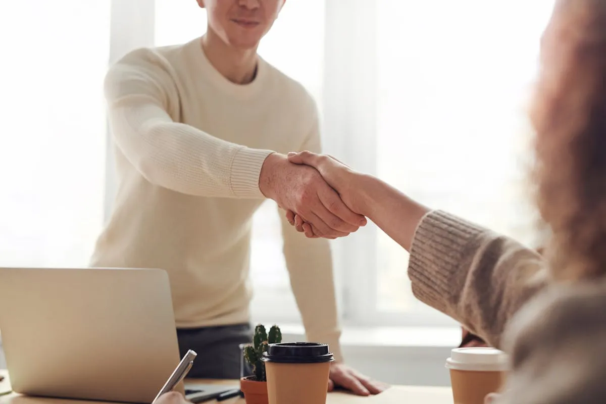 Beratungsgespräch mit Handschlag am Besprechungstisch