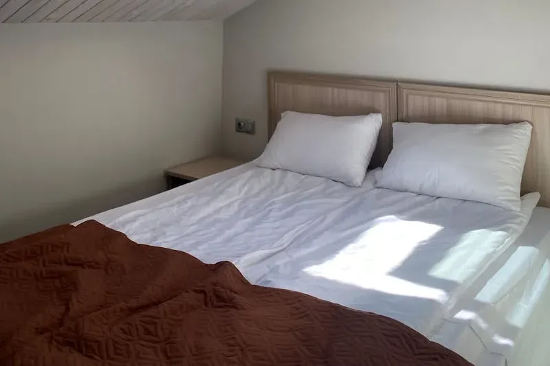 Ausgebautes Schlafzimmer unter der Dachschräge, das durch ein Dachfenster mit Tageslicht geflutet wird
